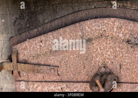 Detailed view of aged, corroded metal showing layers and a vintage latch mechanism, highlighting texture and decay Stock Photo