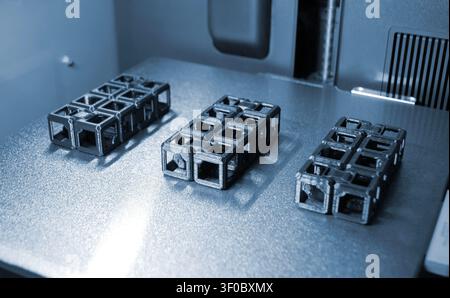 An object printed on a 3D printer on a work surface 3D printer. Object printed on 3D printer from molten plastic black color. Additive new modern manufacturing technology. 3D printing FDM technology Stock Photo
