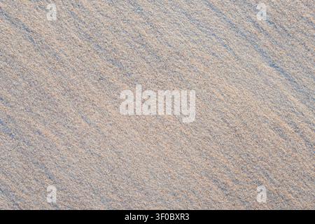 Natural fine seashore sand texture with delicate ripple patterns on a clean beach surface. Ideal background for coastal and summer themes Stock Photo