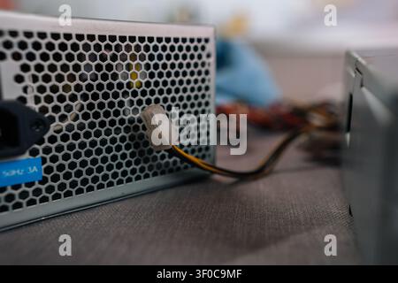 Computer power supply unit distributing electricity to components, showing its ventilation grid, ac in puta connected wire ready for installation or Stock Photo