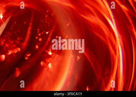 Abstract image featuring swirling red light patterns with circular shapes and reflections, ideal for use in artistic projects or as a vibrant backgrou Stock Photo