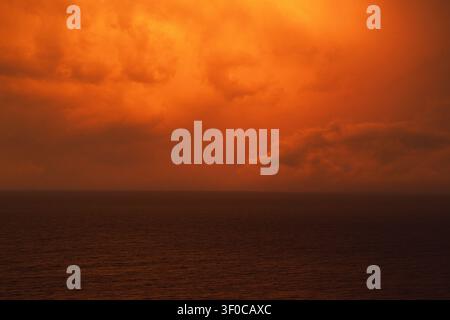 A red apocalyptic sunset seascape. Sea and clouds. Stock Photo