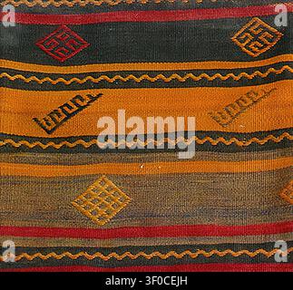 Traditional hand-woven kilim rug displaying intricate striped patterns and folk art symbols, reflecting ancient craftsmanship and cultural textile her Stock Photo