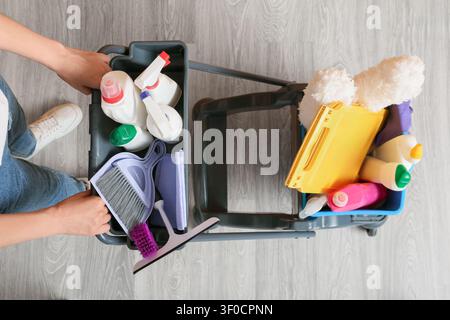 Person pushing cleaning supplies cart with various cleaning products Stock Photo