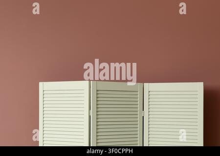 White wooden room divider against brown wall Stock Photo