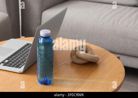 Plastic water bottle on table with laptop and wooden knot decor Stock Photo