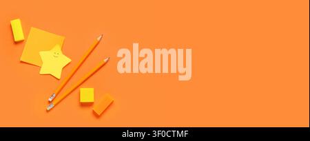 Yellow stationery items on orange background with copy space Stock Photo