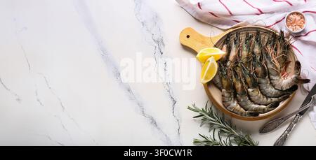 Raw shrimp with lemon and rosemary on plate Stock Photo