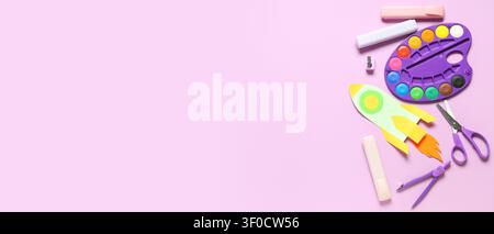 Colorful kids craft supplies with paper rocket on pink background Stock Photo