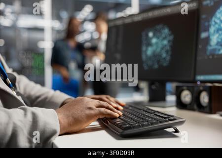 Computer scientist uses a desktop computer in a data center to manage AI simulation and optimize server infrastructure. Stock Photo
