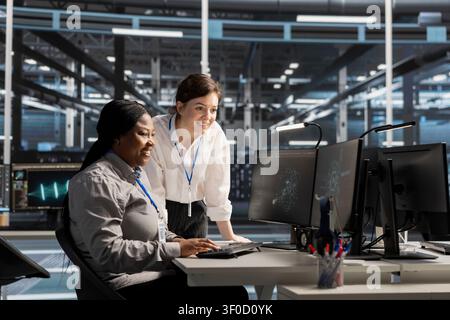 Smiling data center engineer uses a clipboard to review server infrastructure, diagnostics and AI technology in a data center. Stock Photo