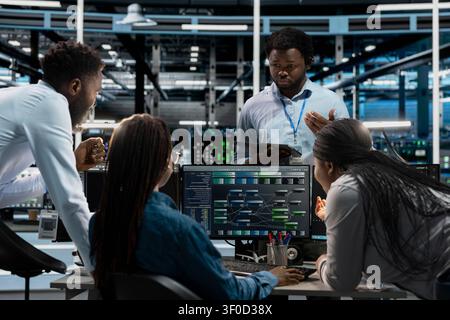 System administrators use a PC in a server farm to visualize AI neural networks and brainstorm while overseeing artificial intelligence systems. Stock Photo