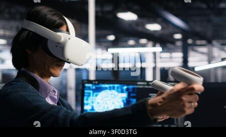 Data center engineer uses a VR headset to inspect AI neural networks and server systems in a high-tech facility. Stock Photo