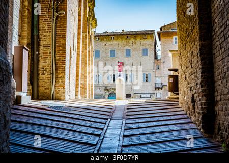 Steep brick street with historic buildings in Urbino, Italy Stock Photo
