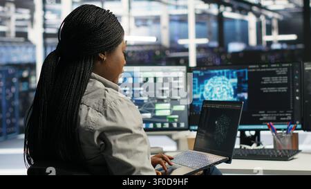 Data center IT expert working with notebook computer to apply AI technology minimizing system downtime. Stock Photo