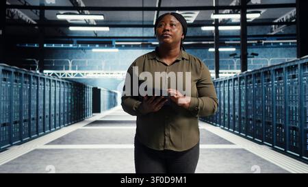 Data center engineer manages software updates in a server room to keep data center systems stable. Stock Photo