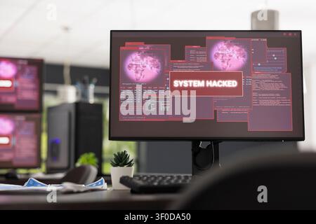 Vacant startup office displays computer screen with hacked system alert and error code. Digital security concept highlights cyber attacks, compromised servers and modern business vulnerability. Stock Photo