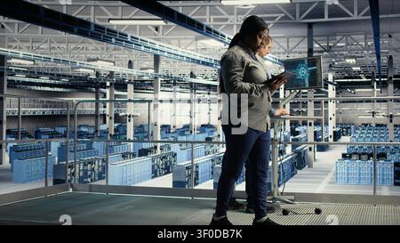 Server facility software developers roll out machine learning software on infrastructure racks. Stock Photo