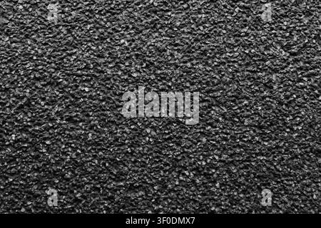 High resolution texture of black asphalt surface with fine dark gravel stones, perfect for architectural visualization, design backdrops, and abstract Stock Photo
