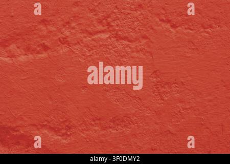 Red, worn plaster on the wall. Texture of an old, damaged concrete wall. Stock Photo