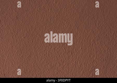 Brown concrete wall texture.   Rough, freshly painted brown plaster. Stock Photo