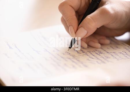 Female writing on copybook, closeup focus on handwriting, closeup Stock Photo