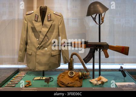 Berlin, Germany - 23 May 25: Display of East German uniform, rifle, helmet and equipment at the Berlin Stasi Museum in Berlin, Germany. Stock Photo