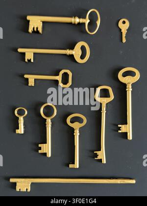 Collection of Different Vintage Golden Keys Arranged on Black Background Stock Photo