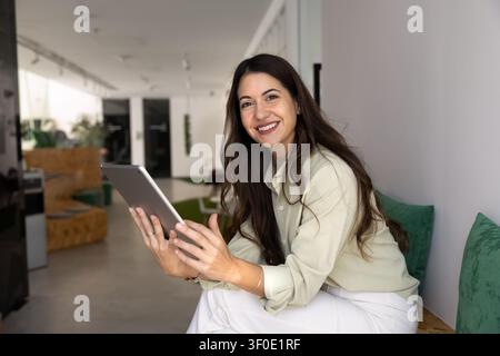 Portrait of smiling female employee using digital tablet in office Stock Photo