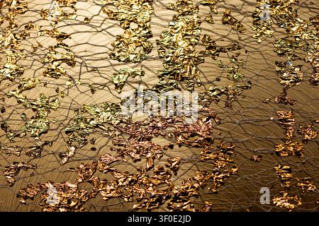 Golden luxury wallpaper in metallic gloss. Golden shiny gold flakes on surface. Golden abstract design for branding art. Golden glowing background Stock Photo