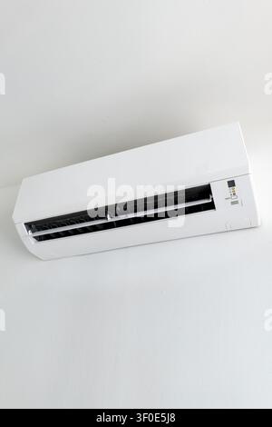 Split system air conditioner mounted on white wall, home cooling appliance Stock Photo