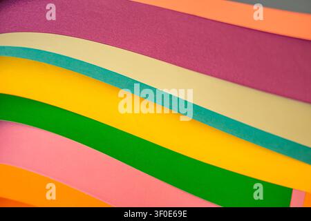 Abstract background of colorful paper sheets layered in waves. Showing vibrant tones of pink, green, yellow, blue, orange and purple with smooth textu Stock Photo