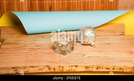 Festive holiday ornament and candle on rustic wooden surface with bamboo background Stock Photo