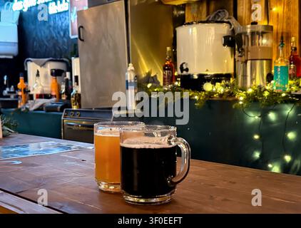 Mulled wine punch cups on a wooden bar top with a festive background of bottles  Stock Photo