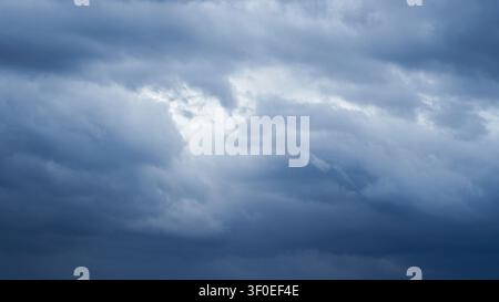 Dramatic overcast sky with dense dark blue clouds gathering before a rainstorm Stock Photo