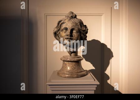 Berlin, Germany - 23 May 25: Stone portrait head displayed on a pedestal with dramatic shadow inside the Bode Museum in Berlin, Germany. Stock Photo