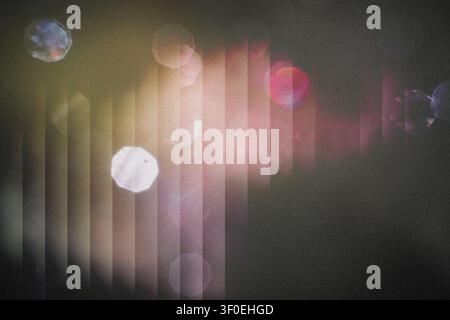 Abstract background showing blurred light shining through vertical blinds creating colorful bokeh Stock Photo