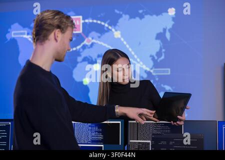 Team collaborating in a cybersecurity operations center with data visualization screens Stock Photo