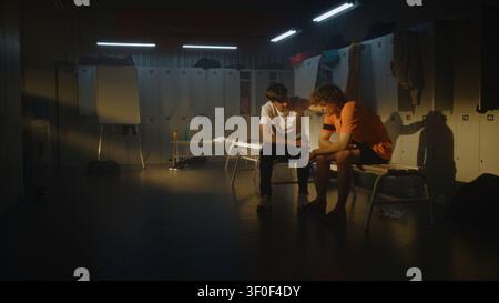 Coach Reassures Teenage Football Player Following Setback, Creating Calm and Supportive Atmosphere in Empty Team Locker Room. Mentorship, Character Building, and Emotional Recovery Beyond Competition. Stock Photo
