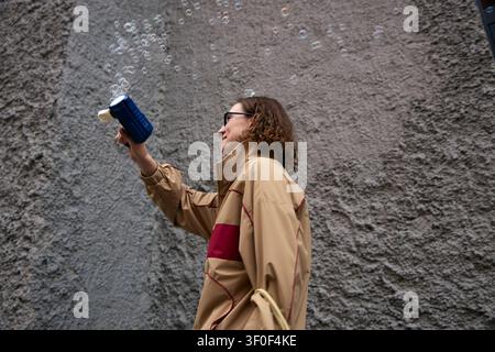 Adult Woman Blowing Soap Bubbles for Leisure and Outdoor Fun Stock Photo