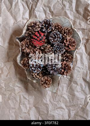 Pine cones in a leaf-shaped bowl, Christmas decoration Stock Photo