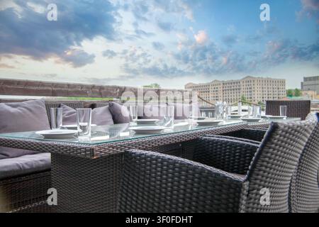 Restaurant interior. Row of empty plates and glasses on a long table ready to serve Stock Photo