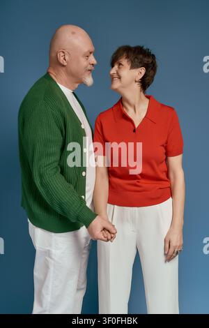 A loving senior couple poses together, dressed stylishly and smiling happily. Stock Photo