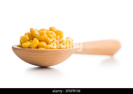 Closeup of bright sweet corn kernels piled in a wooden spoon on a clean white background, highlighting texture, color and freshness . ideal for food, Stock Photo