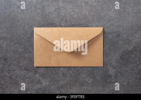 Brown kraft paper envelope on gray concrete background with copy space. Top view. Stock Photo