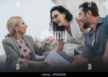 Business colleagues having a friendly outdoor meeting and discussion over documents Stock Photo