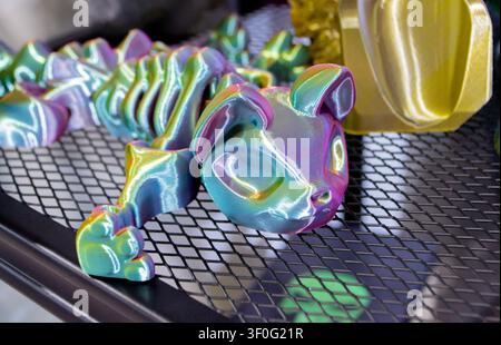 Colorful toy cat printed on 3D printer. Art purple blue model printed on 3D printer from molten plastic. FDM technology. Fused Deposition Modeling. Additive modern manufacturing technology 3D printing Stock Photo