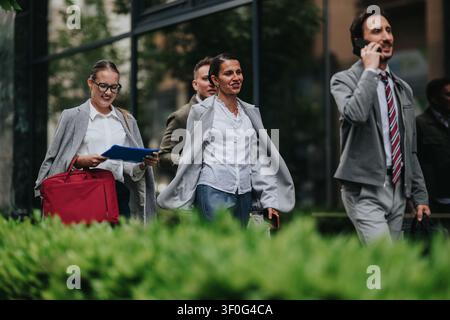 Business colleagues walking through city street outside office building on a workday commute Stock Photo