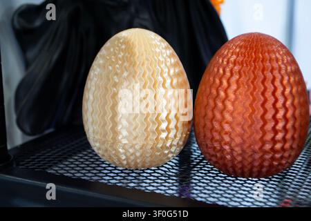 Object toys eggs yellow brown color printed on 3D printer. Models printed on 3D printer from molten plastic. FDM. Fused Deposition Modeling. Additive modern manufacturing technology. 3D printing Stock Photo