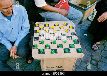 Checkers board game with plastic bottle tops for pieces, Medina, Marrakech, Morocco, North Africa Stock Photo